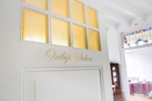 une porte blanche avec des fenêtres jaunes au-dessus de celle-ci dans l'établissement Residentie Villa de Wael, à Domburg