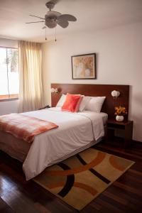 une chambre avec un grand lit avec des oreillers rouges dans l'établissement Vilmor Hotel Boutique, à Trujillo