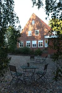 una mesa y sillas frente a un edificio en Hotel Alte Landschule en Langballig