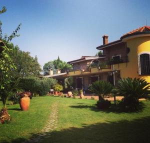 une grande maison avec une pelouse devant elle dans l'établissement Villa Luisa, à Montoro Inferiore