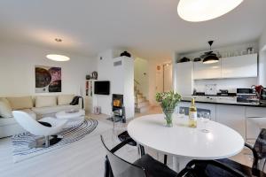 a kitchen and living room with a white table and chairs at "Over the Rainbow" - Lovely house close to the Beach in Gdańsk