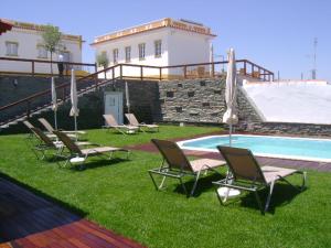 a group of chairs sitting next to a swimming pool at Casa Esquível in Mourão