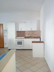 a kitchen with white cabinets and a sink at Riva Apartment Negrelli in Riva del Garda
