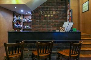 a bar with wooden chairs and a brick wall at Domino Hotel in Nizhny Novgorod