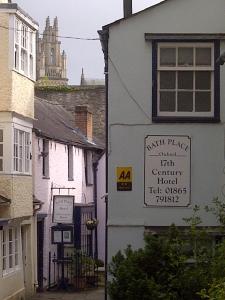 a white building with a sign on the side of it at Bath Place Hotel in Oxford