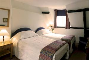 a hotel room with two beds and a window at Bath Place Hotel in Oxford