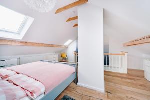 a bedroom with white walls and wood floors and a bed at Harzallerliebst in Braunlage