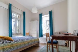 a bedroom with a bed with blue curtains and a desk at The Pearl in Talbyeh in Jerusalem