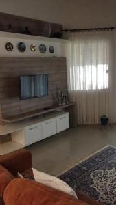 a living room with a flat screen tv on a wall at Casa Blumenau in Blumenau