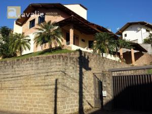 a house behind a brick wall with a fence at Casa Blumenau in Blumenau