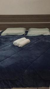 Una cama azul con dos toallas encima. en Casa Blumenau, en Blumenau