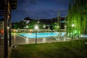 a swimming pool at night with chairs and lights at Dimitris Villa Hotel in Matala