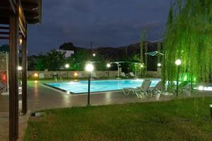 a swimming pool at night with chairs and lights at Dimitris Villa Hotel in Matala