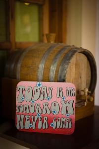 a happy is like a wooden never sons sign next to a barrel at Dimitris Villa Hotel in Matala
