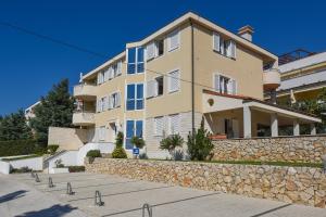 a large building with a stone wall in front of it at Apartments Luaniva 50m from the see in Novalja