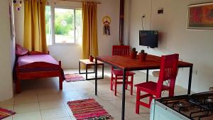 cocina con mesa de madera y sillas rojas en Sueño del Champaquí en Villa Las Rosas