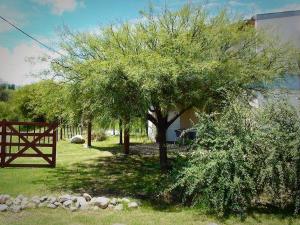 un árbol en un patio junto a una valla en Sueño del Champaquí en Villa Las Rosas