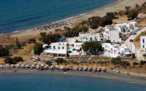 an aerial view of a beach with white buildings and chairs at Tinos apartments Zalonis in Agios Ioannis