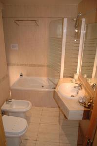 uma casa de banho com um WC, uma banheira e um lavatório. em Hostal Stop em Cantalejo