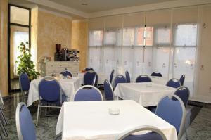 a conference room with white tables and blue chairs at Hostal Stop in Cantalejo