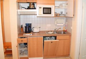a small kitchen with a sink and a microwave at Ferienwohnung am Plöner See in Ascheberg