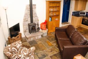 a living room with a couch and a fireplace at Hay Barn in New Mills