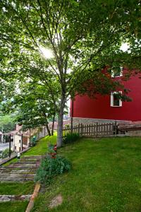un edificio rosso con un albero in un cortile di Apartamentos El Picoretu a Mestas de Con