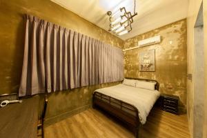 un dormitorio con una cama y una ventana en Slow Inn, en Tainan