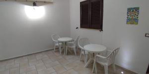 a room with white tables and chairs and a wall at B&B Nonna Irene in Matino