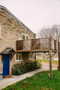 uma casa com um telhado de madeira ao lado em The Bike Shed em New Mills