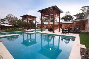 a swimming pool with a gazebo next to a house at The Sanctuary in Noosa North Shore