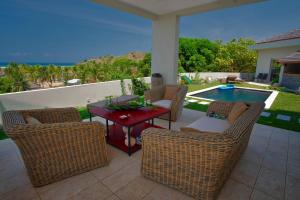 een patio met stoelen, een tafel en een zwembad bij Villa Kintana Naka in Andoany