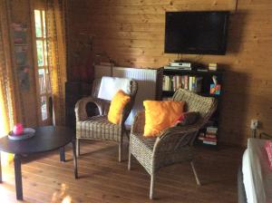 a living room with two chairs and a tv at B&B Zeijen in Zeyen