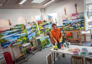 a person standing in a room with paintings at Art Apartment Sønderbygaard in Vinderup
