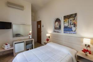 a hotel room with a bed and a television at Esperance 2 in Ermoupoli