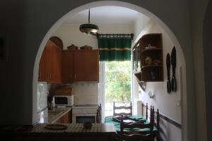 einen Torbogen in einer Küche mit einem Tisch und einem Fenster in der Unterkunft Traditional House in Peraia