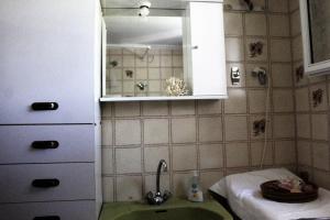 ein kleines Badezimmer mit Waschbecken und Spiegel in der Unterkunft Traditional House in Peraia + 29 Fotos