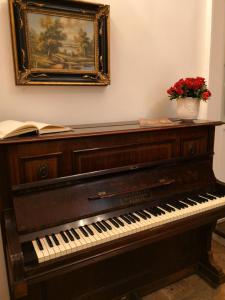 - un piano dans une pièce ornée d'un vase de fleurs dans l'établissement La Dimora Del Professore, à Naples