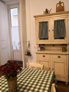 cocina con mesa y mantel a cuadros en La Dimora Del Professore, en Nápoles