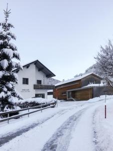 a snow covered road in front of a building at Am Mellenbach Patrizia Kleber in Mellau