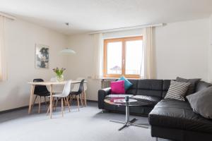 a living room with a black couch and a table at Am Mellenbach Patrizia Kleber in Mellau