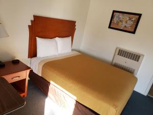 ein kleines Hotelzimmer mit einem Bett und einem Schreibtisch in der Unterkunft Country Inn Marion in Marion