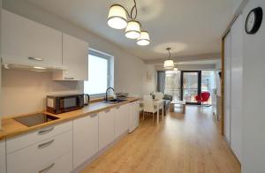 卡爾帕奇的住宿－Apartamenty EverySky Karpacz - Wilcza 3F_P，一间带白色橱柜的厨房和一间客厅