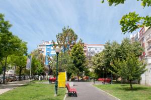 リスボンにあるCharming City Centre Apartmentの赤いベンチと木々と建物のある公園