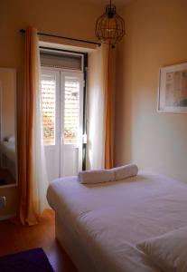 een slaapkamer met een wit bed en een raam bij Charming City Centre Apartment in Lissabon