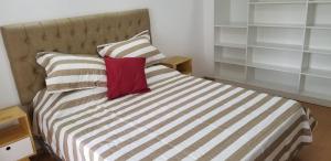 1 dormitorio con 1 cama con almohada roja en Recoleta Unique agüero apartments en Buenos Aires
