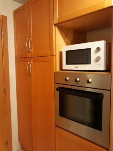 a microwave sitting on top of a stove in a kitchen at Parque das Nações in Lisbon