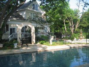 a house and a swimming pool in front of a house at Strickland Arms Bed and Breakfast in Austin