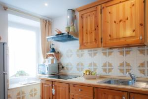 a kitchen with wooden cabinets and a sink at Casa Scalet in Fiera di Primiero