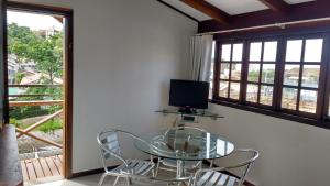 ボンビーニャスにあるApartamentos Morada Aquitâniaのテレビ付きの客室で、ガラスのテーブルと椅子が備わります。 +23枚の写真